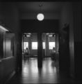 A view from the hallway of two people sitting and eating in a lounge in the Science Building at UMD