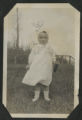 Child standing in the front yard of a house