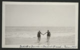 Judith Hartley and Jean Lewis walking out of the water holding hands at Miami Beach