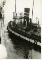 Tug boat near a ship in harbor, probably in Bremerhaven.