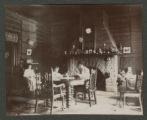 Three unidentified people by a fireplace inside a cabin at Cass Lake