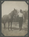 John Valen standing beside a horse
