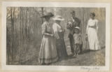 Members of the Hartley family standing on a pathway through the woods surrounding the maple sugar camp in Trout Lake