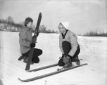 Two people putting on skis at Rock Hill in winter