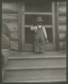 Child standing on the front steps of a cabin in Cass Lake