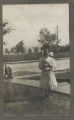 Child standing in the grass by a flight of stairs near a street