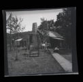 Brook Lodge and dining room, Mrs. Roberts sitting on wooden sidewalk