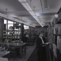 Student reading a book near bookshelves in the Curriculum Library
