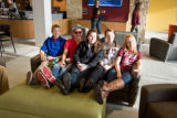 A group of five students sitting on a couch together in Kirby Student Center
