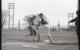 Action shot of UMD 1986 women's softball players at first base