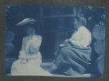 Carrie Eliza Hartley sitting with another person on the steps of a cabin at Cass Lake