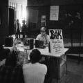 Student fraternity using stereo tape deck equipment in hallway