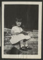 Caroline Hartley Lewis sitting and reading on the front steps of a house