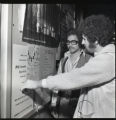 Students viewing a poster at the 1975 Feast of Nations event at UMD