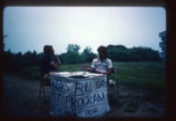 Camp Butwin staff sit at a table with a paper sign in front, Eagan, Minnesota