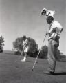 Action shot of UMD 1961 golfer putting ball during free golf
