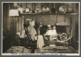 Mrs. d'Autremont sitting by the fireplace of her cottage on London Road