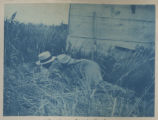 Person sleeping on the ground by a building on Hartley Stock Farm