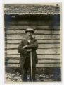 Man standing next to dovetail log structure, Sweden