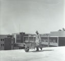 Bricklayer brings mortar in a wheelbarrow on the roof of the Education and Psychology Building