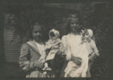 Judith Hartley and another child standing together holding dolls