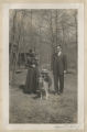 Judith and Guilford "Gil" Hartley with a dog and another unidentified person at the maple sugar camp in Trout Lake
