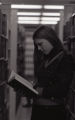 Student in between bookcases in library