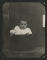 Chester Adgate Congdon II as a baby sitting in a pot in front of a door