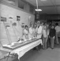 A group of people standing around a cake in Kirby Student Center for its 20th anniversary celebration