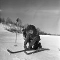 A person crouched down putting on skis at Rock Hill