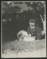 Child sitting with two bushels of apples outside of the Hartley house at 1305 East Superior Street