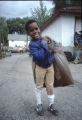 Boy holds a bag of trash over his shoulder during the Mount Sinai Hospital and Phillips neighborhood clean-up, Minneapolis, Minnesota