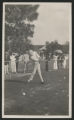Crowd of people gathered a golfer hitting a driver on a golf course