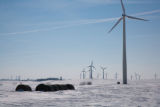 Round hay bales and wind turbines in winter on Buffalo Ridge, Pipestone County, Minnesota.