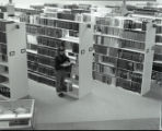 Student looking at books in library