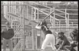 Action shot of UMD 1985 women's softball player #13 winding up to hit ball