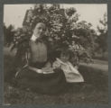 Mary Hartley and Hartley Rogers sitting by a flower bush in the yard of the Peyton House