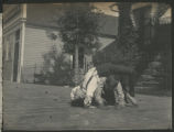 Child crawling underneath another child standing backwards on his hands and feet in front of a cabin at Cass Lake