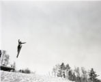 Action shot of UMD 1956 skier doing a jump during a tournament