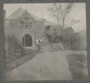 Judith Hartley riding a horse in front of a barn at the Hartley house at 1305 East Superior Street