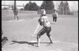 Action shot of UMD 1988 women's softball player winding up to hit ball