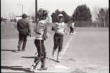 Action shot of UMD 1988 women's softball players at base