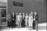 University regent William K. Montague and a group posing in front of Montague building plaque at the building's renaming ceremony
