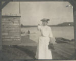 Carrie Eliza Hartley standing on the shore of a lake next to a boat rental and dock