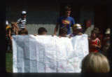 Campers hold a sign that reads, "Negba" with other writings at Camp Butwin, Eagan, Minnesota