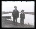 Mr. Erickson and son standing in front of Mud Lake