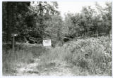 Cable gate on forest road with signage