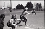 Action shot of UMD 1988 women's softball players at home base