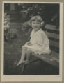 Portrait of Jean Lewis as a child sitting on a bench