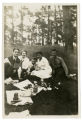 Paul B. Anderson sitting in middle of group at a picnic